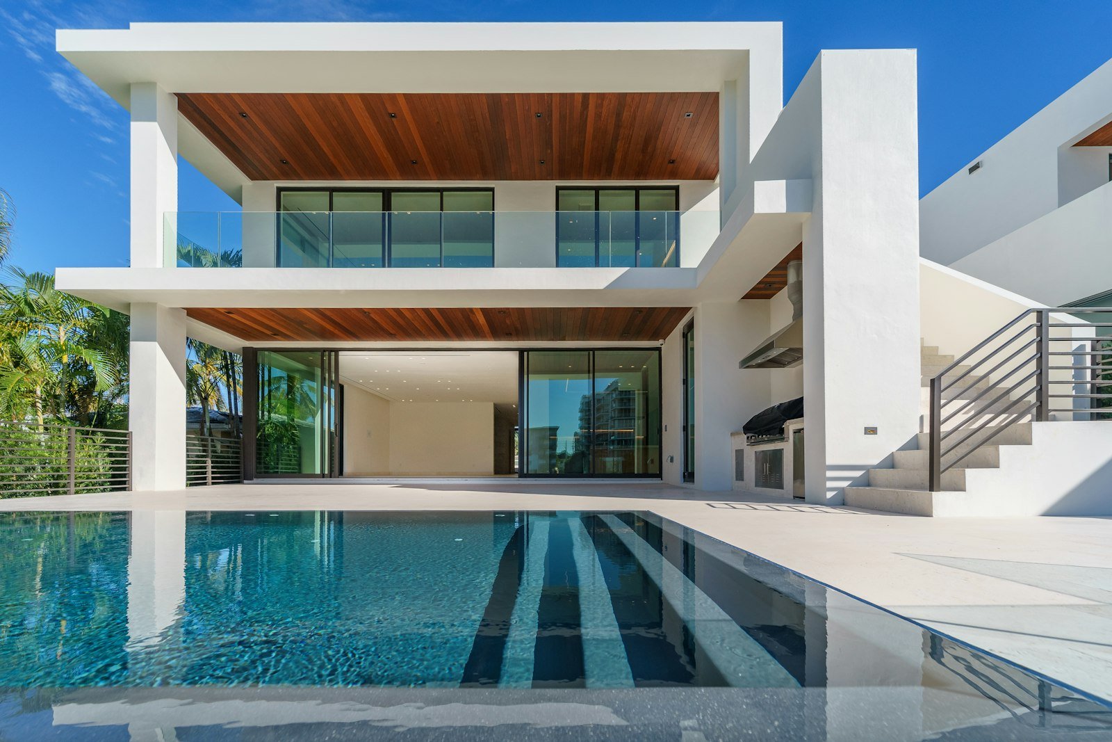 Villa contemporánea iluminada al anochecer con jardín amplio